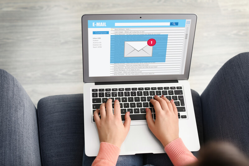 Young woman with laptop checking an email at home