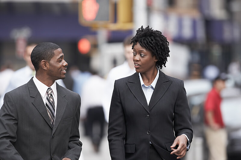 two businesspeople in conversation while walking
