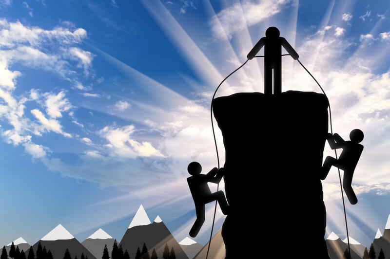 Climber helps ascent of two climbers on a mountain top